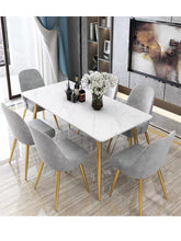 Load image into Gallery viewer, Modern dining set with a white marble table and gold legs, accompanied by gray velvet chairs with gold accents, creating a chic and elegant dining experience. Common questions include ‘Are velvet chairs good for dining rooms?’ and ‘How to maintain a marble dining table?
