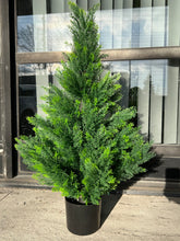 Charger l'image dans la galerie, Artificial evergreen tree in a black pot with vibrant green foliage, placed outdoors, perfect for enhancing the exterior or entrance areas with a natural touch.