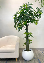 Charger l'image dans la galerie, Artificial money tree with lush green leaves in a stylish white textured planter, placed beside a cozy white armchair in a modern indoor setting, perfect for enhancing office or home decor