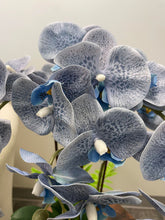 Load image into Gallery viewer, A close-up of artificial blue-speckled orchid flowers with realistic details. Frequently asked question: How do I maintain the vibrant colors of artificial flowers over time?