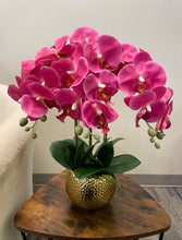 Load image into Gallery viewer, A vibrant bouquet of artificial pink orchids in a golden textured planter with realistic leaves. Frequently asked question: What are the best types of artificial orchids for home decor that look realistic?