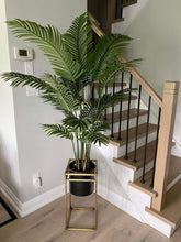 Charger l'image dans la galerie, Artificial palm tree in a gold plant stand, adding a modern touch to a staircase area.