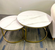 Load image into Gallery viewer, Set of two round marble-top coffee tables with gold metal frames, placed in a modern living space. Frequently asked questions include 'What are the benefits of nesting coffee tables?' and 'How to care for marble coffee tables?