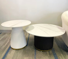 Charger l'image dans la galerie, What are the best small coffee tables for modern spaces? This image features two round coffee tables with white marble tops and ribbed bases—one in white and one in black. The sleek design and compact size make them ideal for minimalist or contemporary living rooms, offering both functionality and style.