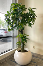 Charger l'image dans la galerie, Artificial money tree with lush green leaves in a stylish white textured planter, placed beside a cozy white armchair in a modern indoor setting, perfect for enhancing office or home decor