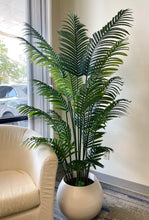 Charger l'image dans la galerie, Artificial palm plant in a modern white ceramic pot, placed beside a luxurious white sofa creating a chic and contemporary living room decor.