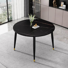 Charger l'image dans la galerie, How do I choose the right dining table for my space? Image of a round black marble dining table with minimalist gold accents in a modern dining room, offering a stylish and space-saving solution.