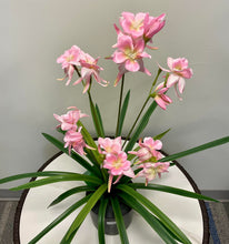 Charger l'image dans la galerie, A potted artificial plant featuring delicate pink flowers with long green leaves, placed on a white round table.
