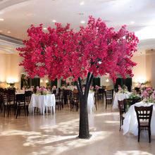 Load image into Gallery viewer, Elegant artificial tree adorned with red blossoms, featured in a beautifully set event hall with round tables, floral centerpieces, and wooden chairs. Can these decorative trees be customized to match specific event themes?