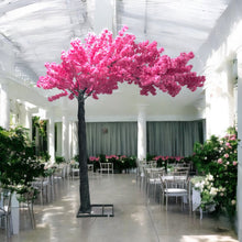 Charger l'image dans la galerie, Elegant artificial cherry blossom tree with vibrant pink flowers set in a luxurious, sunlit wedding venue, adding a romantic flair to the decor. Can this artificial cherry blossom tree be customized for different event themes?