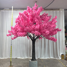 Load image into Gallery viewer, A beautiful artificial pink cherry blossom tree with a sturdy trunk, set on a cement base for stability, against a white curtain backdrop. Does this tree come with a warranty?