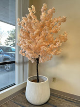 Charger l'image dans la galerie, White textured planter with a ribbed design, holding a tall artificial peach blossom tree with delicate pink flowers, placed indoors near a window. Is this planter stable for taller artificial trees?