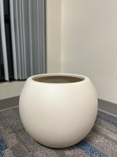 Charger l'image dans la galerie, Minimalist ivory round planter with a smooth matte finish, displayed empty indoors on a carpeted floor near a window. What is the planter's capacity in liters?