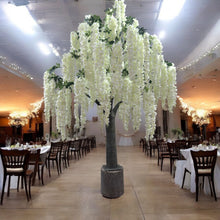 Load image into Gallery viewer, Elegant artificial white wisteria tree with cascading blooms, creating a luxurious ambiance in a wedding or event hall setting. How can this wisteria tree transform your event's atmosphere?