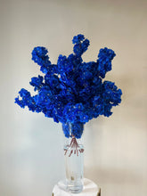 Load image into Gallery viewer, Vibrant blue artificial flowers elegantly arranged in a tall, clear glass vase filled with water, showcased on a chic marble and gold pedestal. Ideal for weddings, events, and upscale décor. How can these striking blue blooms transform your event?