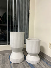 Charger l'image dans la galerie, Set of two white ribbed cylindrical planters with a modern textured design, displayed empty indoors near a window on a carpeted floor. Are these planters suitable for heavy plants?