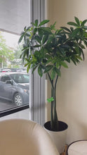 Charger et lire la vidéo dans la visionneuse de la Galerie, Artificial money tree with lush green leaves in a stylish white textured planter, placed beside a cozy white armchair in a modern indoor setting, perfect for enhancing office or home decor.