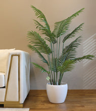 Charger l'image dans la galerie, Artificial palm tree with green fronds, placed in a sleek white pot next to a white sofa, adding a natural touch to a modern, well-lit living room.