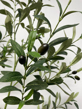 Charger l'image dans la galerie, Close-up view of the artificial olive tree's leaves and small dark olives, showing the detailed texture and realistic design of the foliage against a neutral background