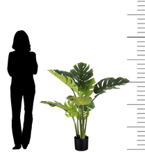 Charger l'image dans la galerie, Artificial monstera plant measuring approximately 4 feet tall, displayed in a black pot. The image features a silhouette of a person for scale, highlighting the size of the plant. The monstera has large, split leaves with a natural green color, perfect for adding a tropical touch to indoor spaces