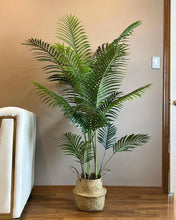 Charger l'image dans la galerie, Artificial palm tree with green fronds, placed in a sleek white pot next to a white sofa, adding a natural touch to a modern, well-lit living room.