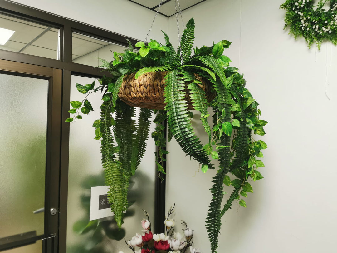 An artificial plant in pot inside an office.
