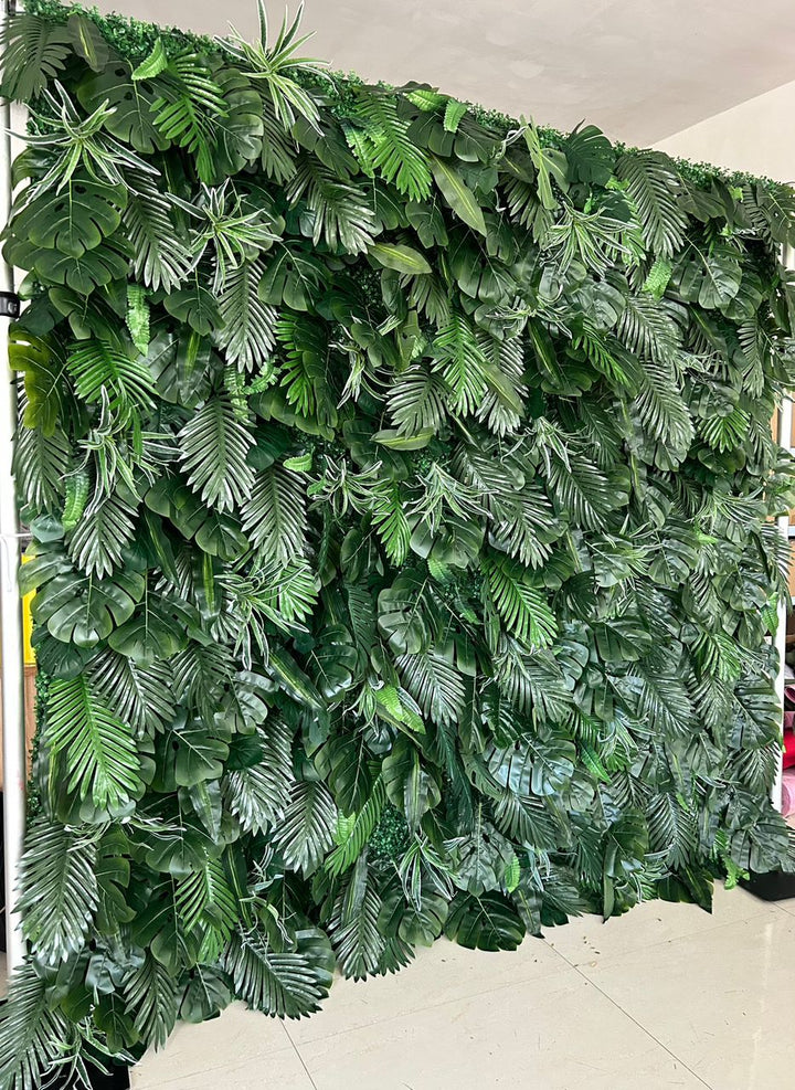 Artificial tropical green leaf backdrop featuring a variety of realistic foliage. Perfect for event decoration, photo booths, and indoor or outdoor settings. How durable is this artificial greenery wall for extended outdoor use? Can the individual leaves or sections be rearranged for custom designs?