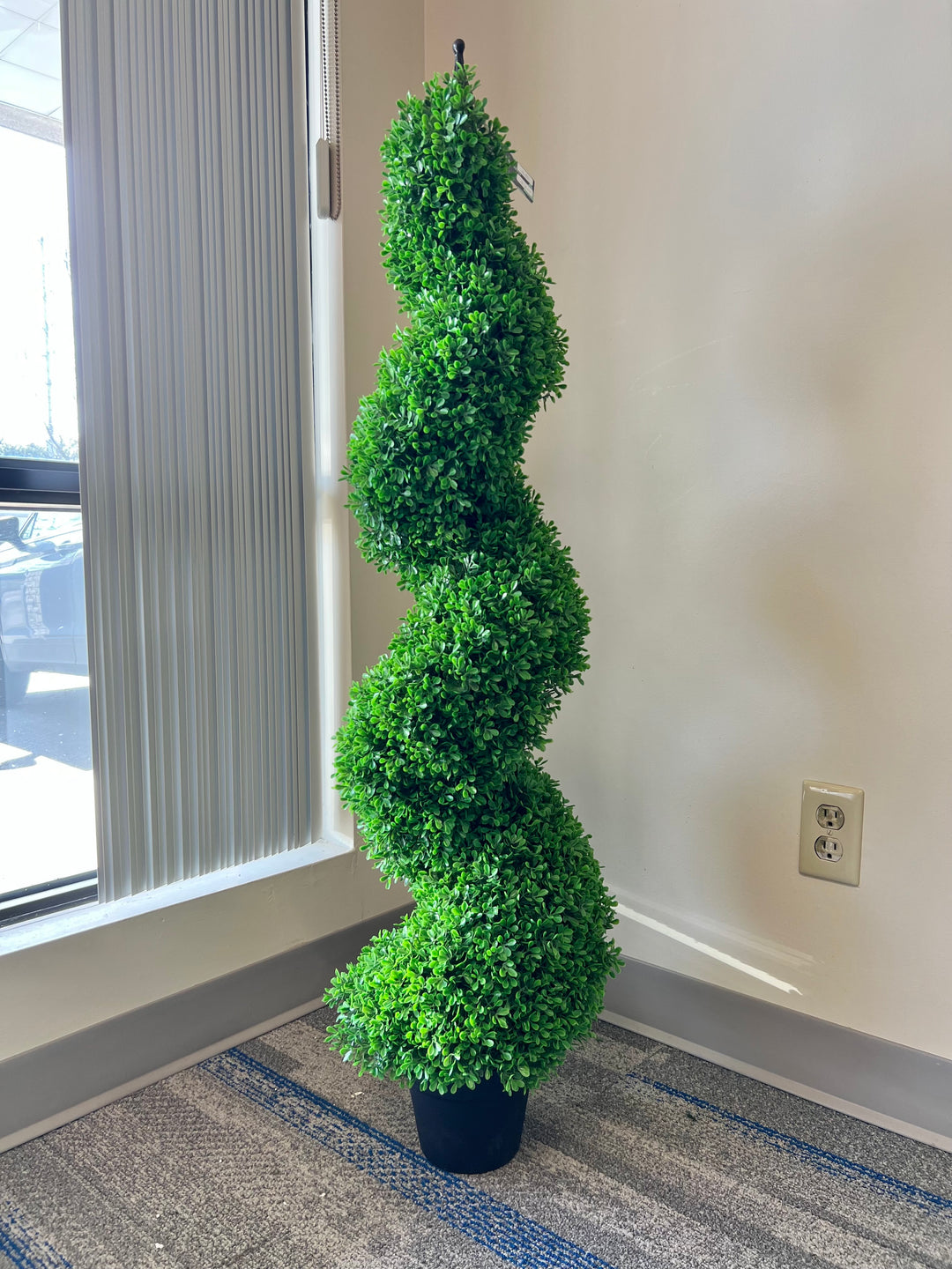 artificial spiral topiary in a sleek black pot, perfect for adding a touch of greenery and sophistication to indoor or outdoor spaces.
