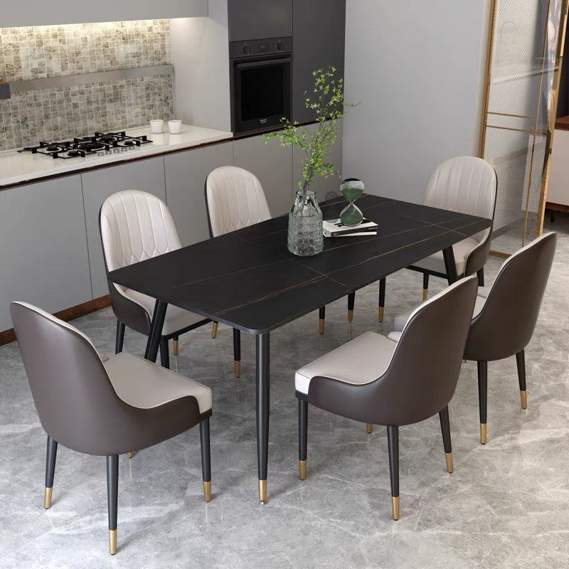 Modern black dining table with gold accents, paired with cream and brown upholstered chairs, in a minimalist kitchen setting. Commonly asked questions include 'What materials are best for easy-to-clean dining tables?' and 'How to match dining chairs with different table styles?