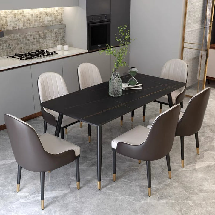 Modern black dining table with gold accents, paired with cream and brown upholstered chairs, in a minimalist kitchen setting. Commonly asked questions include 'What materials are best for easy-to-clean dining tables?' and 'How to match dining chairs with different table styles?