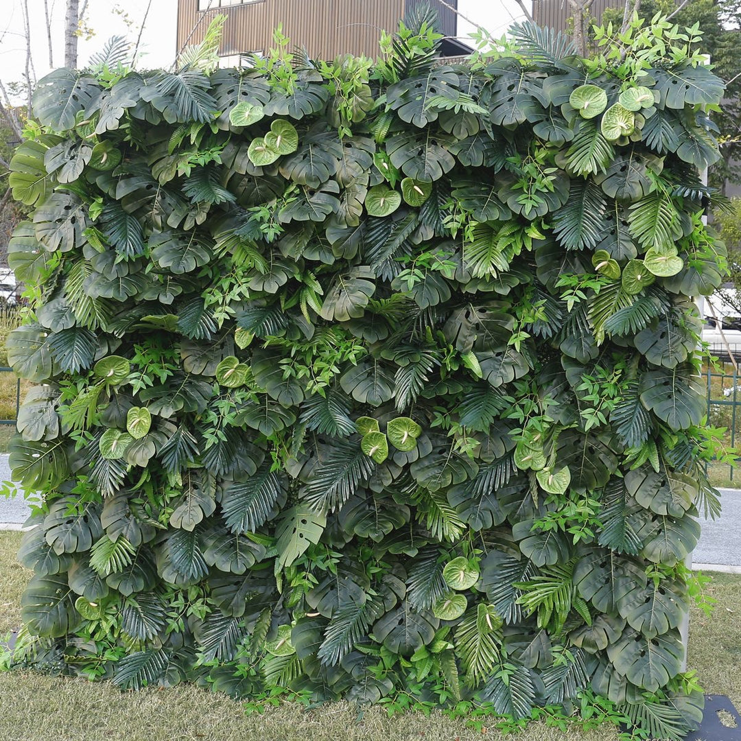 Artificial greenery wall featuring a variety of green tropical leaves, designed for event backgrounds, commercial spaces, and indoor plant decor. Can this backdrop add a natural ambiance to any space? Is it durable enough for high-traffic areas?