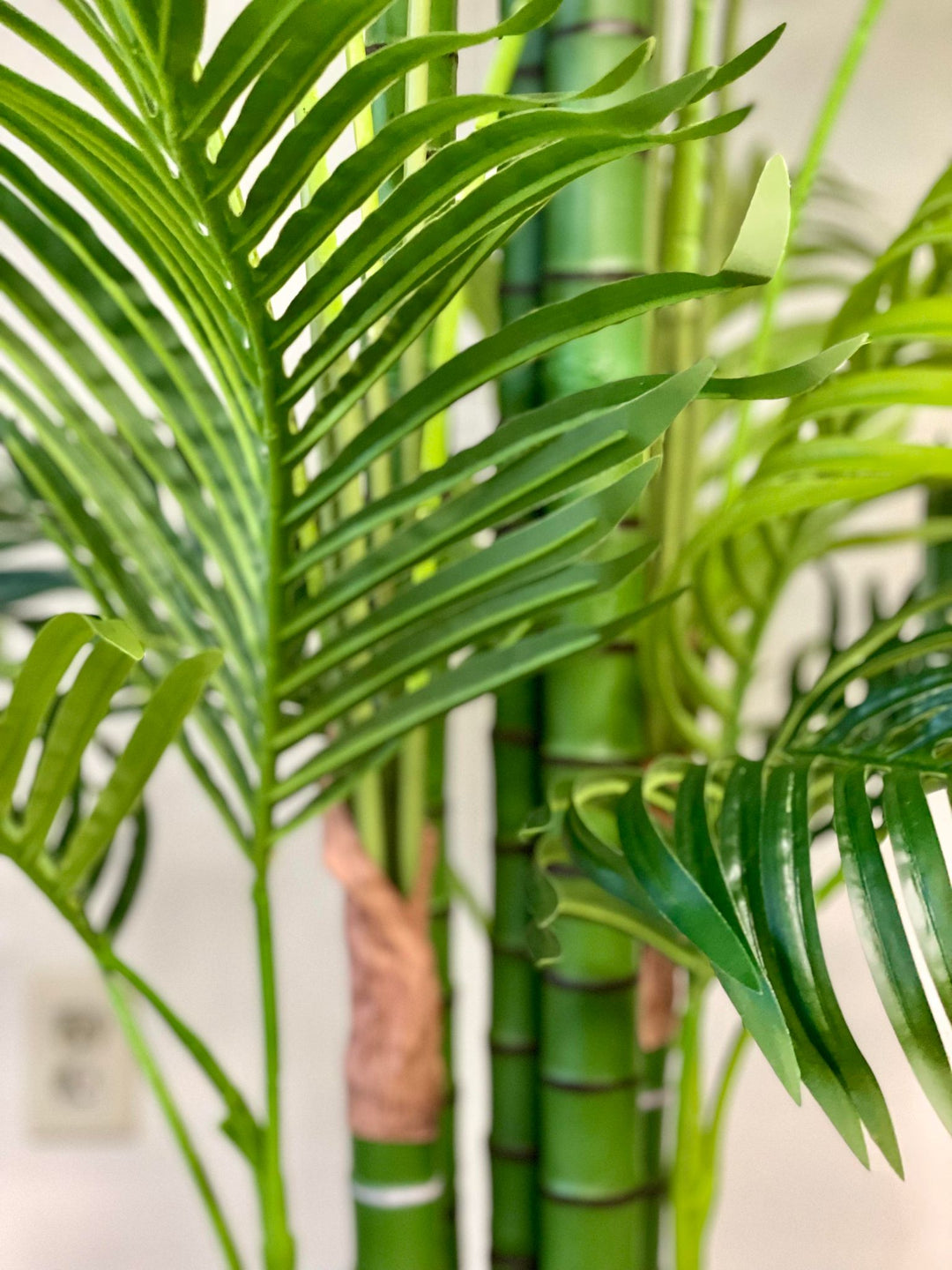 Close-up of vibrant green artificial palm leaves, showcasing their detailed texture and lush tropical aesthetic, perfect for enhancing indoor decor with a natural touch.