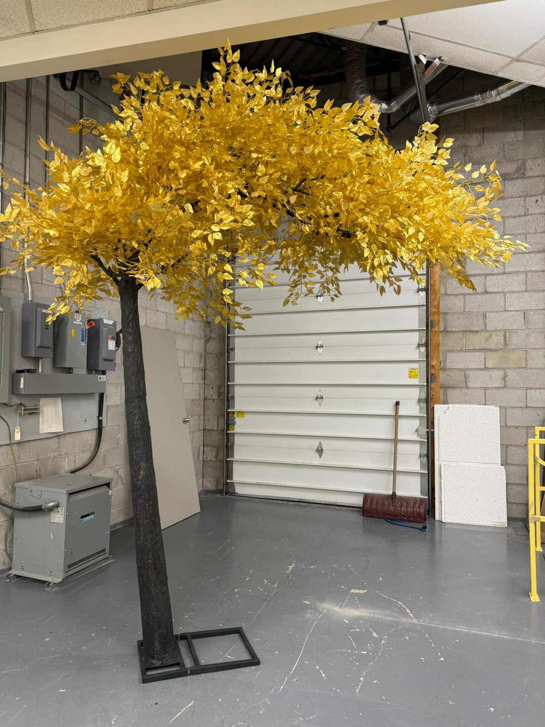 Artificial gold leaf ficus  tree in a warehouse setting