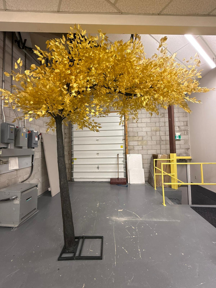 Artificial gold leaf  ficus tree in a warehouse setting