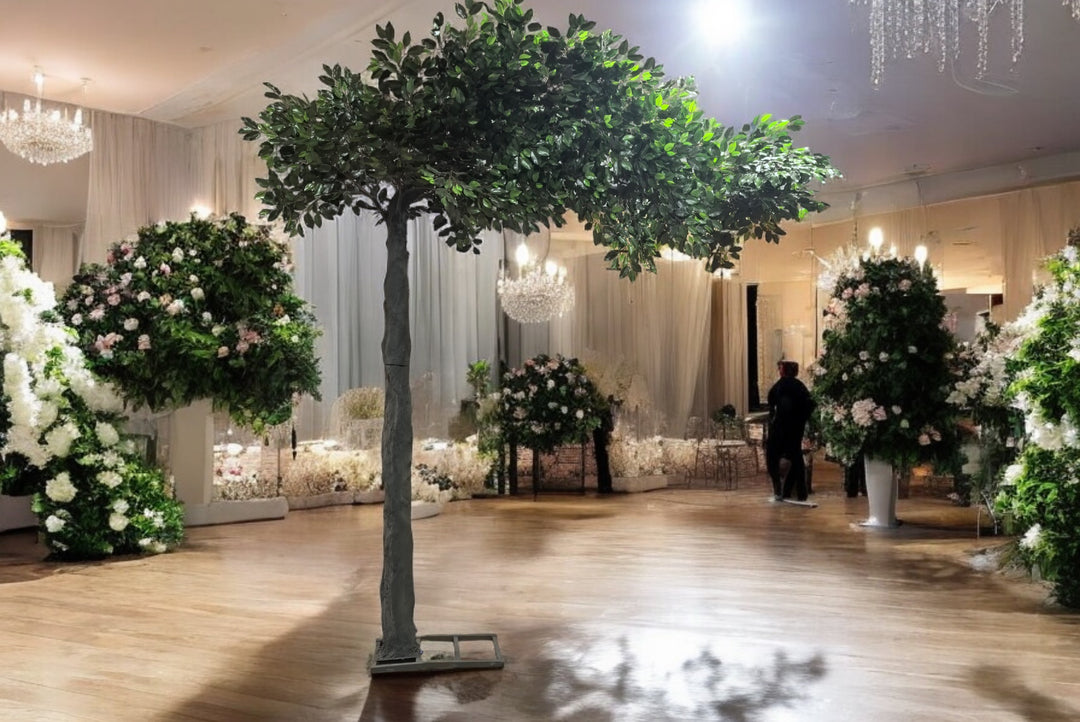 Elegant artificial 10ft ficus tree centerpiece for luxury wedding or event décor, surrounded by floral arrangements and chandeliers. Perfect for creating a natural ambiance indoors. 