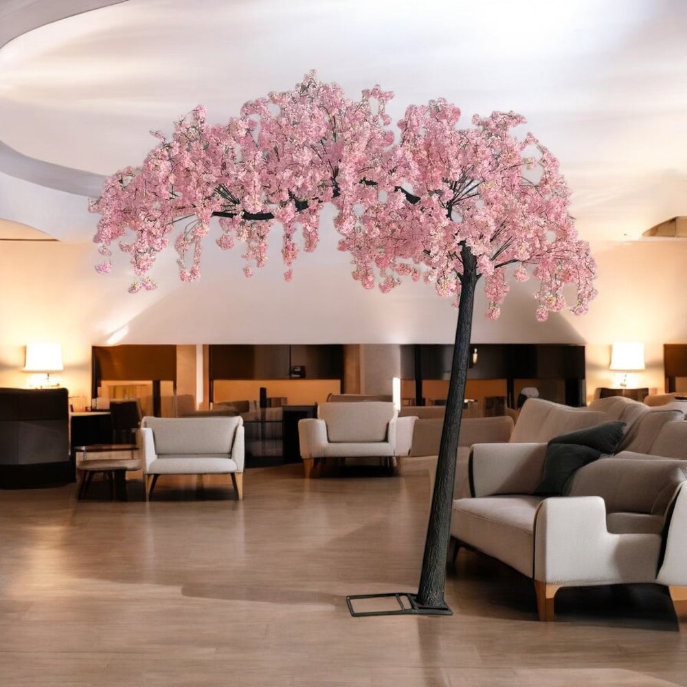 Decorative Artificial pink weeping cherry blossom arch tree in a modern interior setting with furniture.