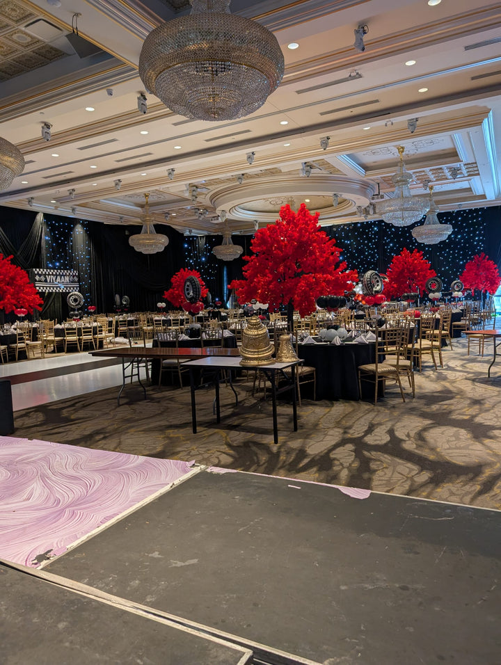 Decorated beautiful event space with red floral cherry blossom arrangements and tables set for a gathering.