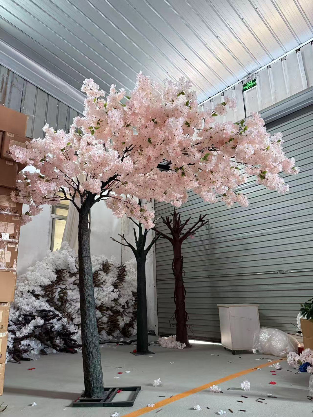 Event-ready cherry blossom floral arch with lifelike blossoms and sturdy frame stored in warehouse.