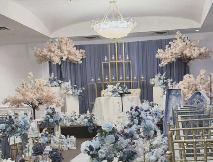 Decorated event space with floral arrangements and a chandelier.
