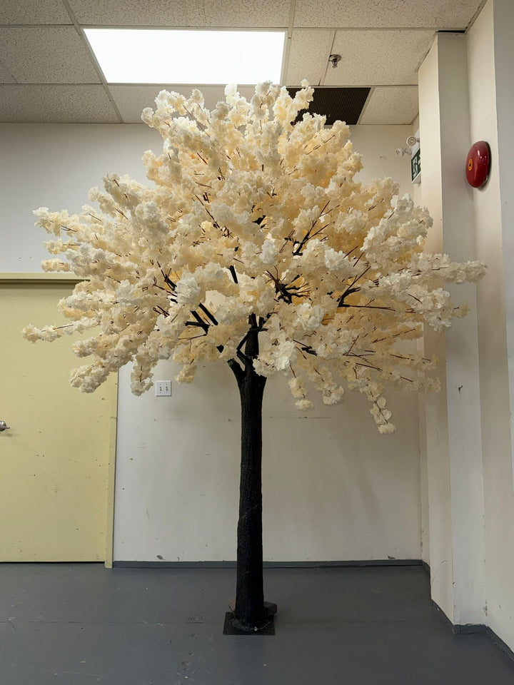 Artificial cream white flowering cherry blossom tree in an indoor warehouse setting