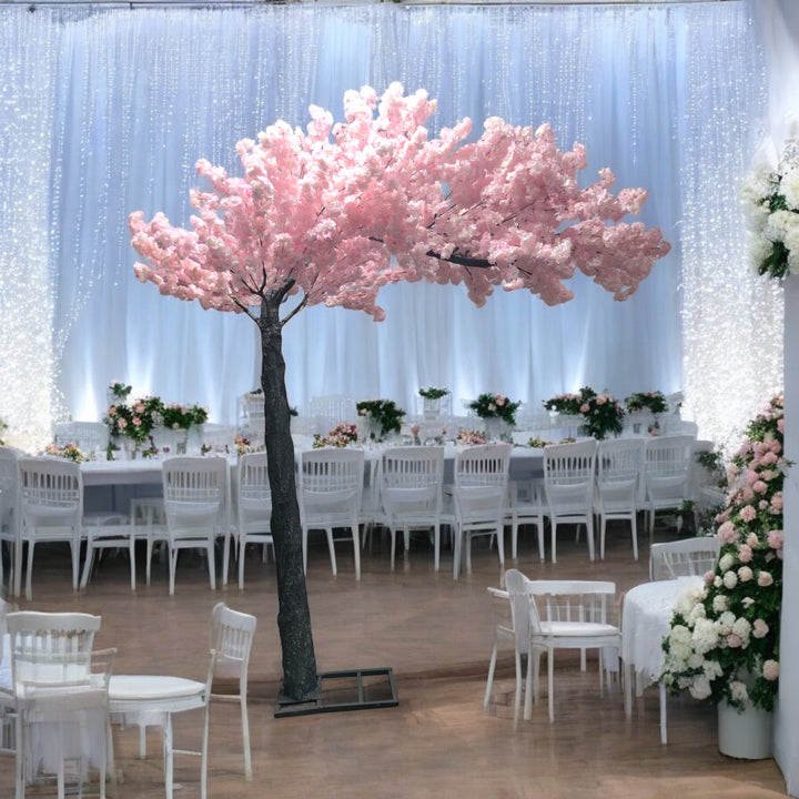 Artificial cherry blossom arch with realistic pink flowers used for styling a wedding interior.