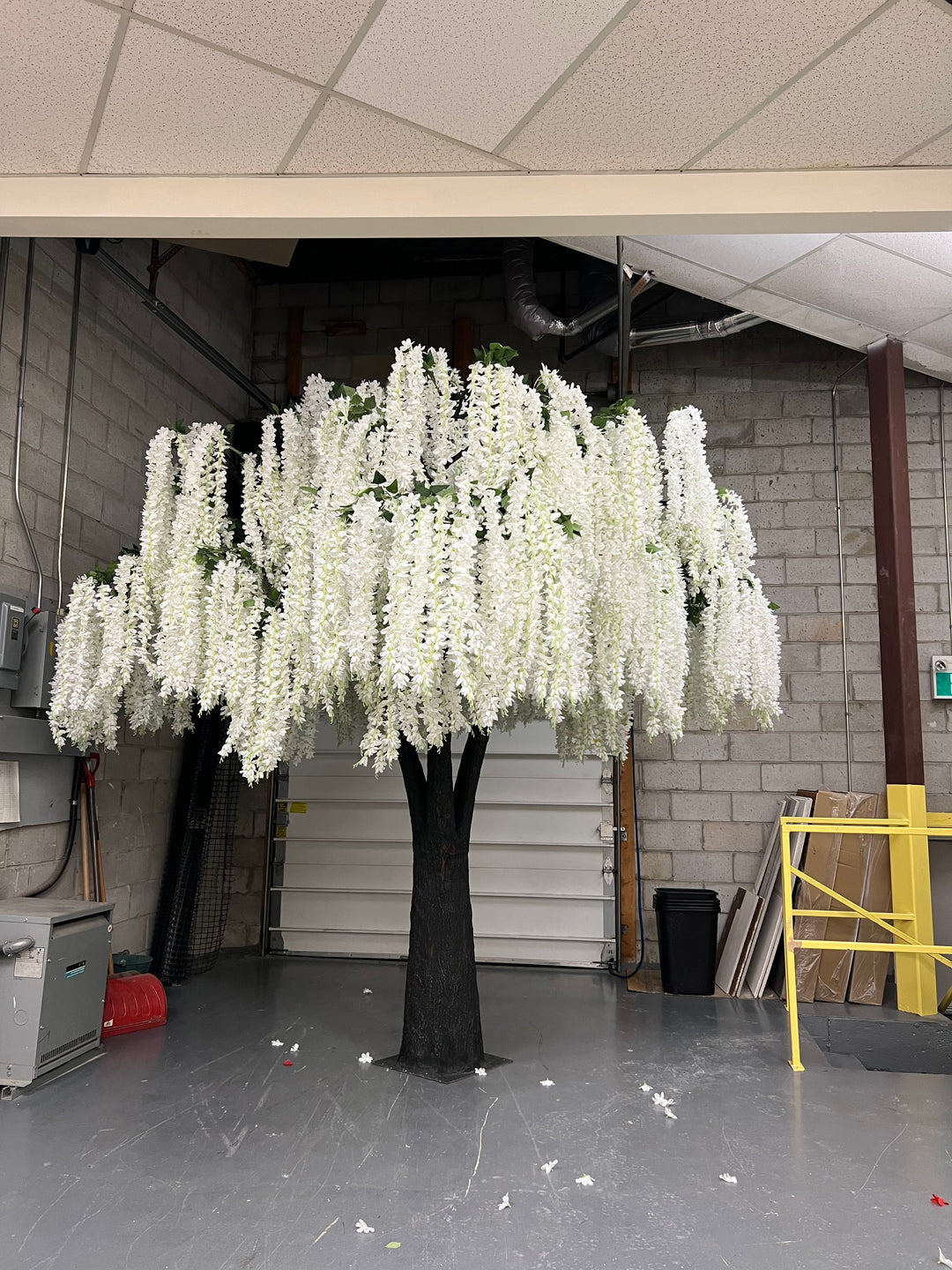 Tall white wisteria floral arrangement in a narrow indoor setting
