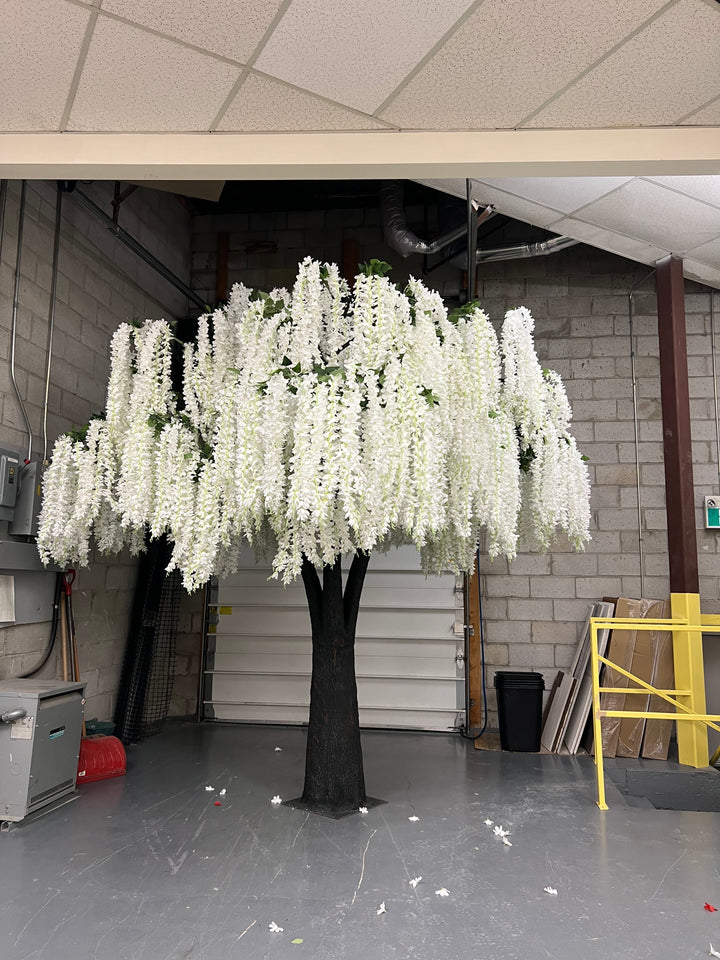 Tall white wisteria floral arrangement in a narrow indoor setting