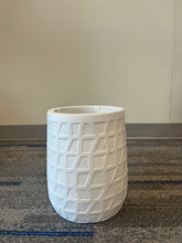 Load image into Gallery viewer, White planter with a geometric textured design, displayed empty indoors on a carpeted floor against a neutral background. What are the height and diameter dimensions of this planter?
