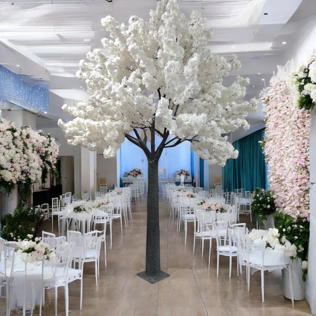 A majestic white artificial blossom tree in an elegant banquet hall adorned with lush green and white floral arrangements. Ideal centerpiece for wedding or formal event decor. Are these artificial trees easy to assemble and disassemble?