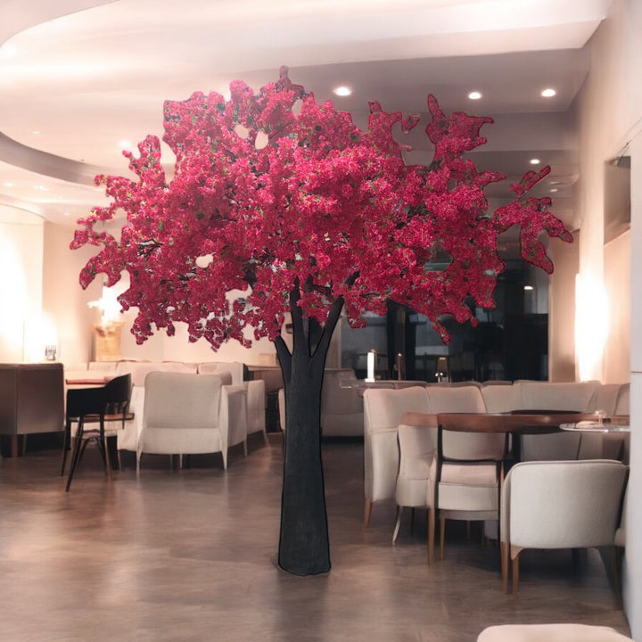 Decorative hot pink bougainvillea tree in a modern restaurant setting with tables and chairs.