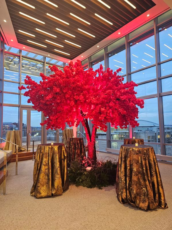 Red cherry blossom sculpture in a modern indoor setting with large windows