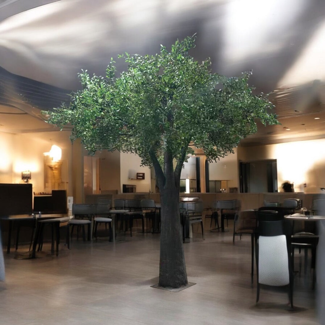 Artificial olive tree in a room with tables and chairs