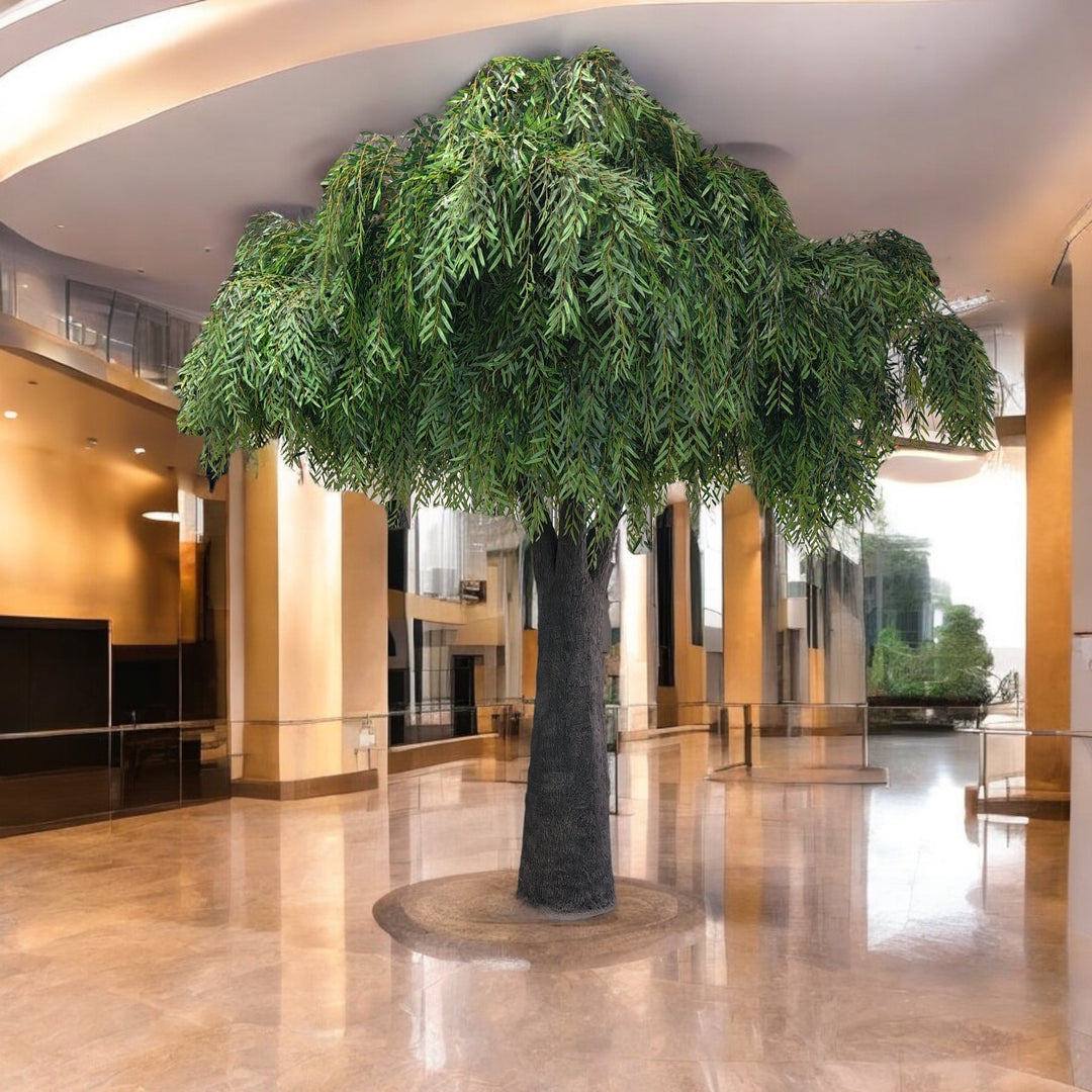 Large artificial tree in a modern indoor setting with reflective floor and curved walls.