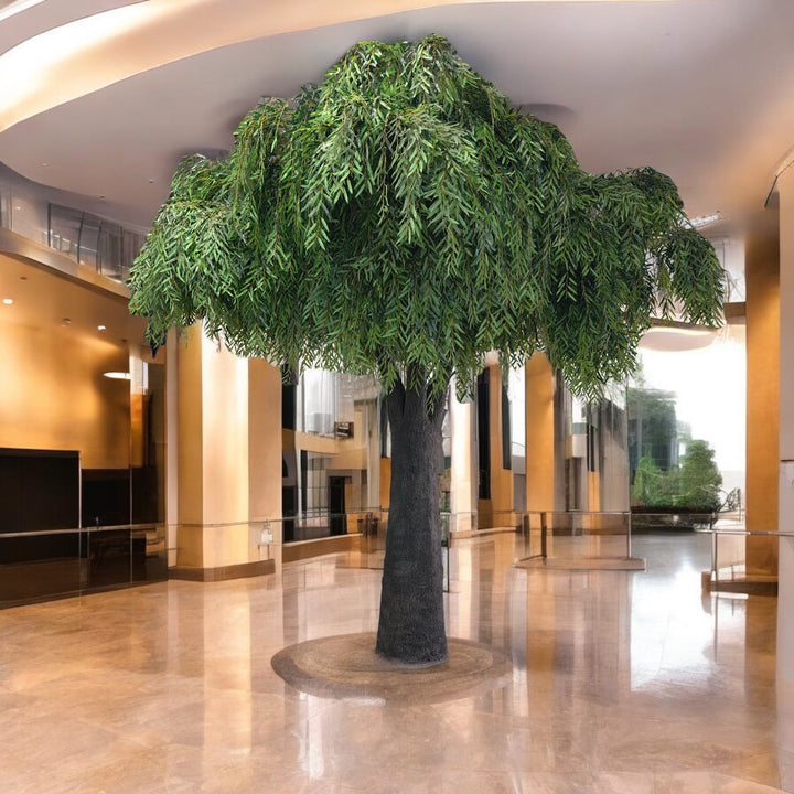 Large artificial tree in a modern indoor setting with reflective floor and curved walls.